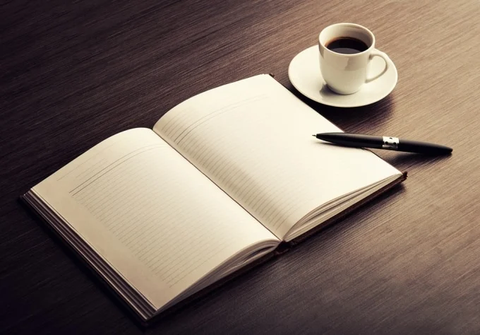 writing Open notebook with a pen and a cup of coffee